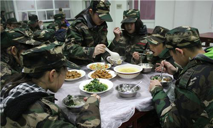 在上海西點(diǎn)軍事冬令營的營地餐廳里孩子們狼吞虎咽的吃著飯菜